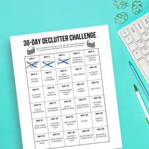 May include: A black and white printable 30-day declutter challenge chart. The chart is divided into 30 squares, each with a day number and a decluttering task. For example, Day 1 is "Dining Table & Bench", Day 2 is "Under the Kitchen Sink", Day 3 is "Small Appliances & Electronics", and so on.