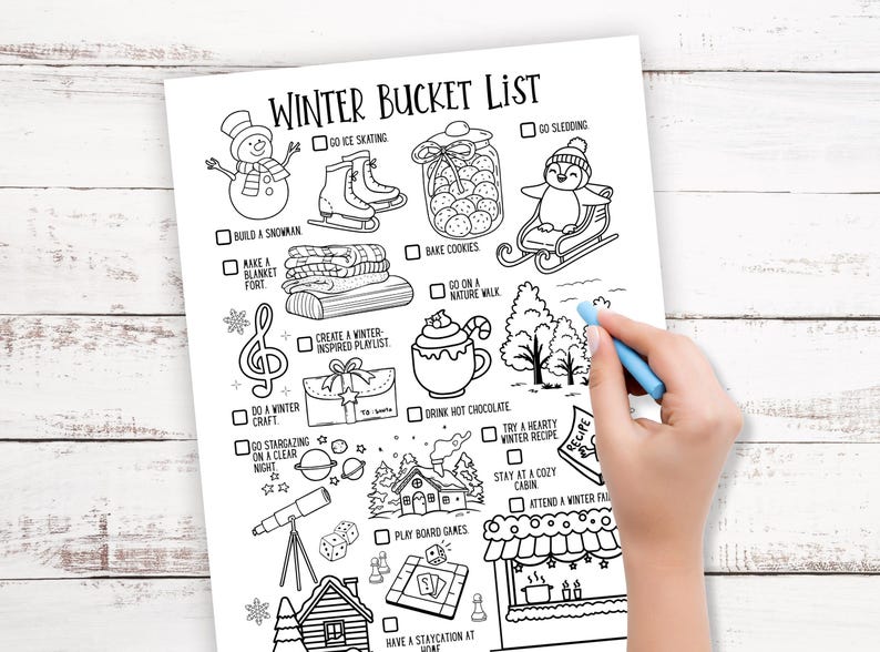 May include: Black and white winter bucket list with illustrations of winter activities, including ice skating, sledding, and baking cookies. A hand with a blue crayon is drawing on the list.