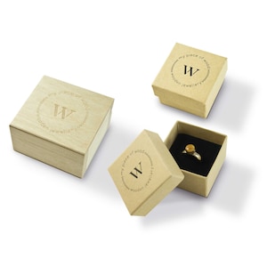 May include: Three wooden ring boxes with the logo "my piece of wood wooden jewellery" and the letter "W" in a circle. The top box is open and shows a ring with a wooden inlay.