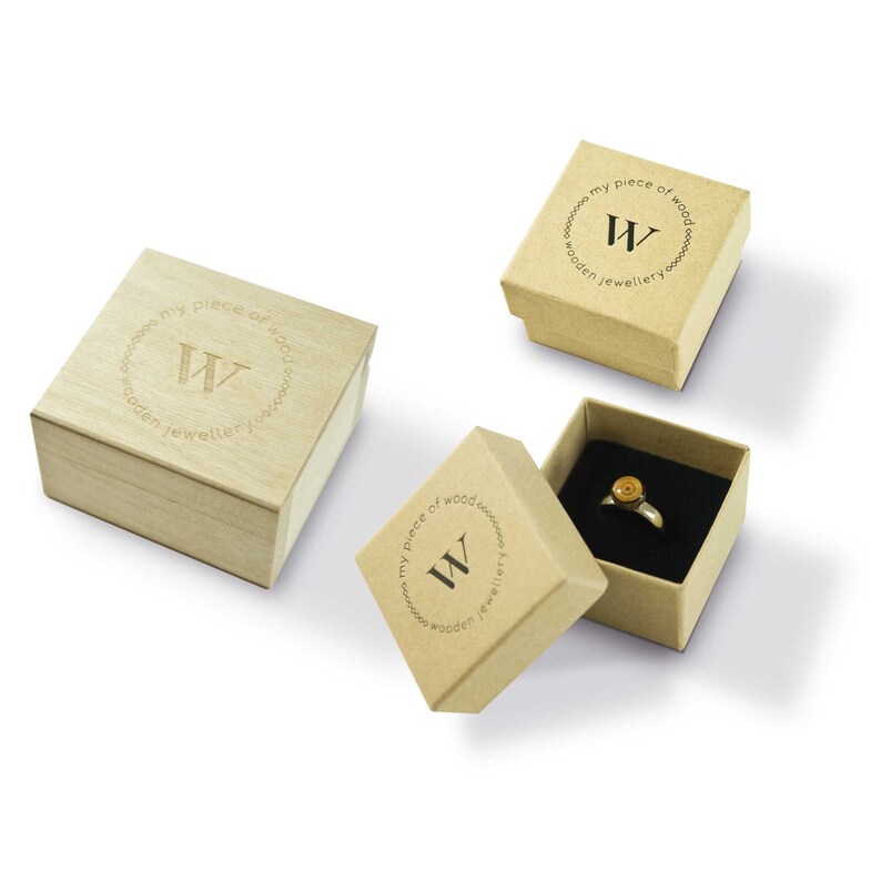 May include: Three wooden ring boxes with the logo "my piece of wood wooden jewellery" and the letter "W" in a circle. The top box is open and shows a ring with a wooden inlay.