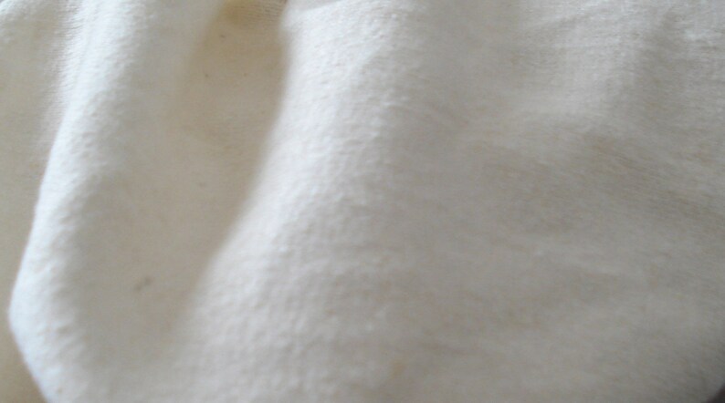 May include: Close-up of a white fabric with a soft, textured surface.