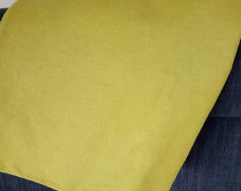 May include: A close-up of a piece of fabric in a bright yellow-green color. The fabric has a smooth, even texture.