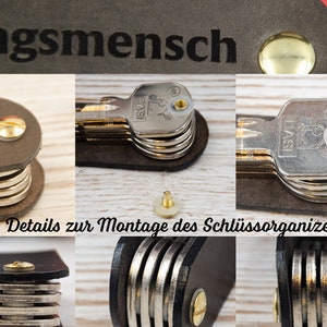 May include: Close-up of a key organizer with multiple keys attached. The organizer is made of brown leather and has a metal screw. The text "Details zur Montage des Schl&uuml;ssorganizers" is visible at the bottom of the image.