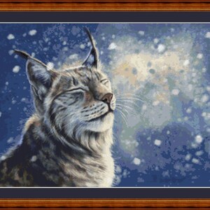 May include: A close-up of a lynx with its eyes closed, looking up at the falling snow. The lynx is light gray with dark spots and has large, pointed ears. The background is a blue-purple color with white snowflakes.