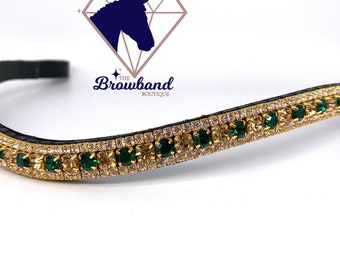 May include: A gold horse browband with emerald green and clear rhinestones. The browband is made of leather and has a gold buckle.
