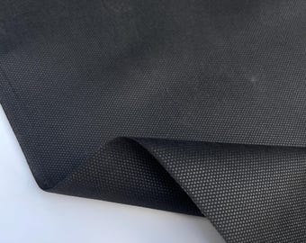 May include: Black fabric with a textured, woven pattern. The fabric is folded in half, showing the underside.