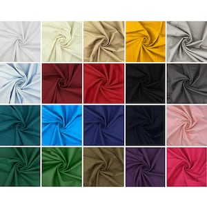 Op de afbeelding: Een verzameling van 20 stofstalen in verschillende kleuren, waaronder wit, beige, geel, blauw, rood, groen, bruin, zwart en roze. De stof is gevouwen en gerangschikt in een rasterpatroon.