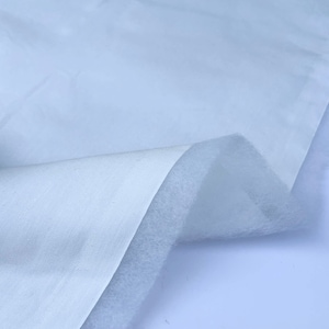 May include: White fabric with a soft, white fleece backing. The fabric is folded over to show the fleece backing.