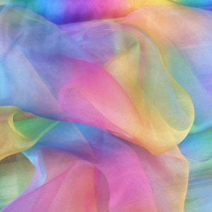May include: Rainbow ombre sheer fabric with a soft, flowing texture. The fabric is translucent and has a gradient of colors, starting with a light blue at the top and fading to a yellow at the bottom.