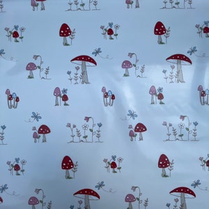 May include: White background with a repeating pattern of red and white mushrooms with blue and pink flowers.