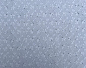 May include: White cotton fabric with a repeating pattern of small, white embroidered flowers.
