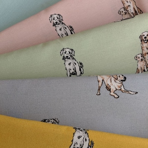 Op de afbeelding: Vijf stofstalen met verschillende gekleurde achtergronden met een herhalend patroon van honden. De honden zijn in zwart-wit geïllustreerd en zijn van verschillende rassen. De stalen zijn op elkaar gestapeld, met de bovenste staal in lichtblauw, gevolgd door een roze staal, een lichtgroen staal, een grijs staal en een geel staal.