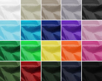 May include: A collection of 24 fabric swatches in various colors, including white, beige, light blue, turquoise, dark blue, purple, pink, green, yellow, orange, red, dark green, navy blue, and black. The fabric has a subtle texture and is likely nylon or polyester.