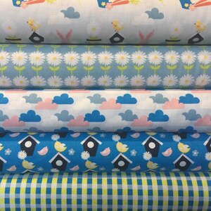 May include: Five different fabric swatches with various patterns. The top swatch is light blue with a white bird and cloud design. The second swatch is light blue with a white daisy pattern. The third swatch is white with pink and blue clouds. The fourth swatch is blue with a white bird and birdhouse pattern. The bottom swatch is a yellow and blue gingham pattern.