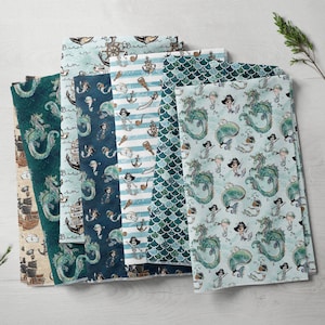 Può includere: Un set di dieci pannelli di tessuto con tema nautico con creature marine, navi e ancore. I pannelli sono in tonalità di blu e verde con accenti bianchi. Il tessuto è stampato con una varietà di motivi, tra cui strisce, squame e pois.