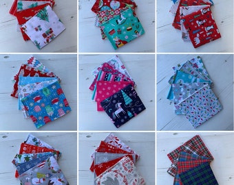 Könnte beinhalten: Neun Stapel von Stoffquadraten mit verschiedenen Weihnachtsmotiven. Jeder Stapel besteht aus fünf Quadraten. Die Muster umfassen rote und weiße Zuckerstangen, Schneeflocken, Rentiere und einen Schneemann.
