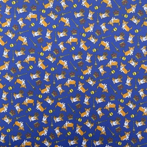 May include: A blue fabric with a repeating pattern of cartoon corgis wearing crowns. The corgis are in various poses, some sitting, some standing, and some running. The crowns are gold and have red jewels. The background is a solid blue.