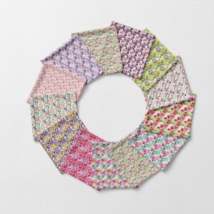 May include: A collection of 10 fabric swatches featuring different floral patterns. The swatches are arranged in a circle, with the floral patterns facing outwards. The fabrics are all white with different colored flowers, including pink, purple, yellow, and red.