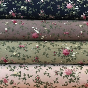 May include: Four rolls of fabric with a floral pattern. The fabric is in shades of pink, green, brown, and blue. The floral pattern features small pink roses and green leaves.