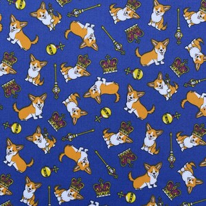 May include: A blue fabric with a repeating pattern of cartoon corgis wearing crowns and holding scepters. The corgis are in various poses, some are sitting, some are standing, and some are running. There are also crowns, scepters, and other royal symbols scattered throughout the pattern.