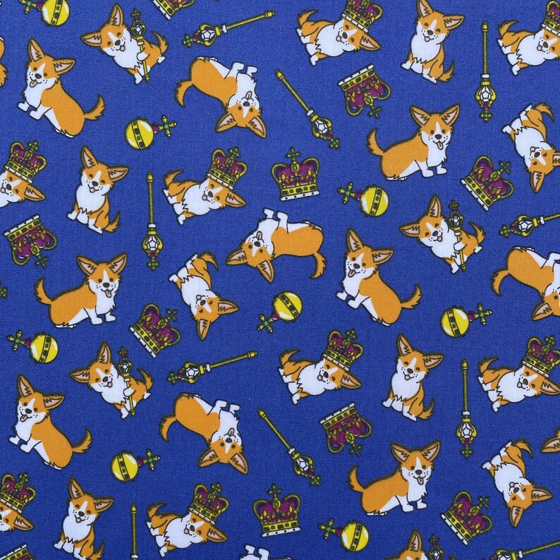 May include: A blue fabric with a repeating pattern of cartoon corgis wearing crowns and holding scepters. The corgis are in various poses, some are sitting, some are standing, and some are running. There are also crowns, scepters, and other royal symbols scattered throughout the pattern.