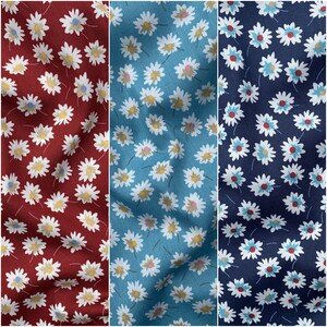 May include: Three fabric swatches with a white daisy pattern on different colored backgrounds. The first swatch is a deep red, the second is a light blue, and the third is a dark blue.