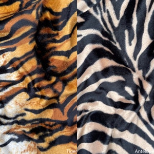 May include: Close-up of two fabric swatches with animal print patterns. The left swatch has a tiger print in orange, black, and white. The right swatch has a zebra print in black, white, and brown. The text "Tiger" is below the left swatch and "Antelope" is below the right swatch.