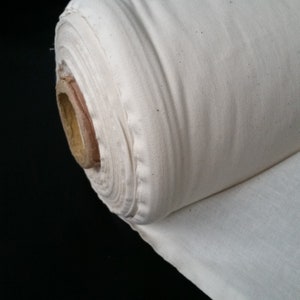 May include: A roll of white cotton fabric, tightly wound and ready to be used for sewing or crafting projects.
