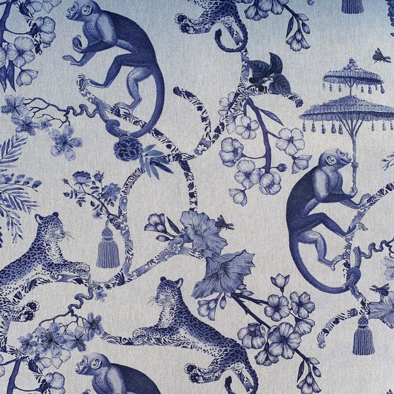 K&ouml;nnte beinhalten: Blauer und wei&szlig;er Blumenstoff mit Affen und Leoparden. Der Stoff hat ein sich wiederholendes Muster aus Affen, Leoparden und Blumen auf hellblauem Hintergrund.