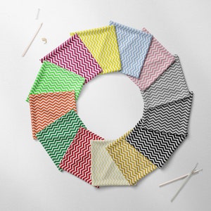 Puede incluir: Un conjunto de 10 muestras de tela con un patrón de chevron en varios colores, incluyendo rojo, naranja, amarillo, verde, azul y gris. Las muestras están dispuestas en círculo sobre un fondo blanco.