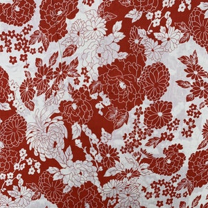 May include: Red and white floral fabric with a repeating pattern of stylized flowers. The fabric has a white background with red flowers and leaves.
