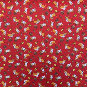 May include: Red fabric with a repeating pattern of white and brown corgi dogs, gold crowns, and scepters. The corgis are wearing gold crowns and holding scepters.