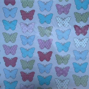 May include: A white fabric with a repeating pattern of colorful butterflies. The butterflies are in shades of blue, green, pink, and red. Each butterfly has a different patterned design.