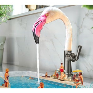 May include: A pink flamingo shaped faucet with a white spout pouring water into a miniature swimming pool with people in it.