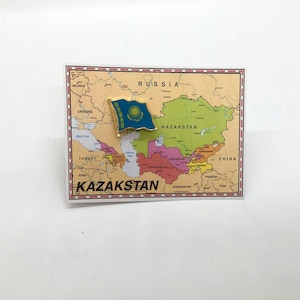 May include: A gold pin with the flag of Kazakhstan on a map of Kazakhstan. The map shows the country's borders and surrounding countries, including Russia, China, and Uzbekistan. The pin is a great way to show your pride in Kazakhstan.