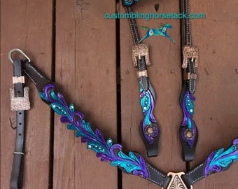 May include: A black leather horse bridle and breast collar set featuring intricate floral tooling painted in vibrant purple and teal. The set includes silver-toned buckles and clear crystal accents. The text customblinghorsetack.com is visible.
