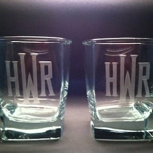 May include: Two clear glass tumblers with a square base. Each tumbler has the initials "HWR" etched into the side.