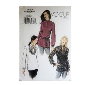 May include: Vogue Patterns 7667 sewing pattern envelope featuring illustrations of three long-sleeved tunic tops. One is a solid plum color with a tie waist, one is white with black embroidery, and one is black lace with a solid black camisole underneath.