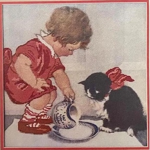 May include: Cross-stitch artwork depicting a young child in a red dress pouring milk from a blue and white pitcher into a plate for a black and white cat with a red bow. The artwork is framed in red.