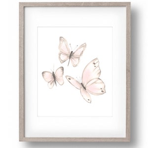 May include: A framed print featuring three delicate pink butterflies with watercolor-like details on a white background.