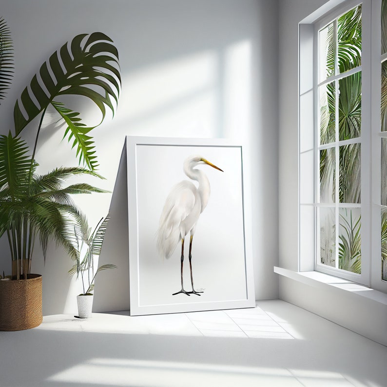 May include: A white framed print of a white egret standing on a white background. The egret has a long, thin neck and long, thin legs. The egret's beak is yellow.