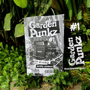 Op de afbeelding: Een zwart-witte afbeelding van een zine getiteld "Garden Punkz #1" met een kleine zwarte versterker en de tekst "1st punkz pretty poison" op de omslag. De zine ligt op een bed van groene planten.