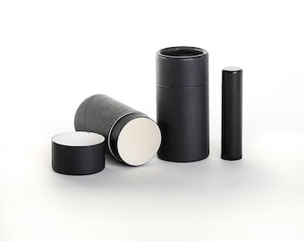 May include: Three black cardboard tubes with white interiors. Two of the tubes are lying down, and one is standing upright. The tubes are all the same size and have a textured surface.