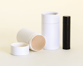 May include: Three white cardboard tubes, one with a brown interior, and a black tube with a rounded top. The tubes are on a light yellow background.