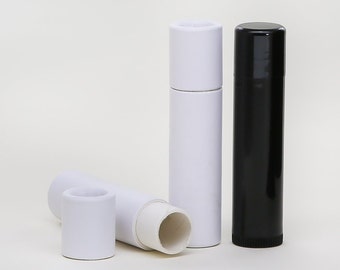 May include: Three lip balm tubes, one white, one black, and one white with the top removed. The tubes are made of cardboard and have a simple design.