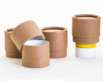 May include: Four brown cardboard tubes with white interiors. The tubes are cylindrical and have a textured surface. One tube is open and the other three are closed.