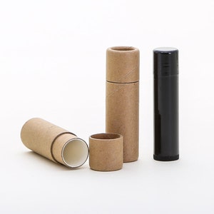 May include: Three cardboard tubes for lip balm or other small items. Two are brown and one is open, revealing a white interior. The third tube is black.