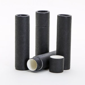 May include: Three black cardboard tubes with white interiors. The tubes are stacked and leaning against each other. The tubes are approximately 1.5 inches in diameter and 3 inches in height.