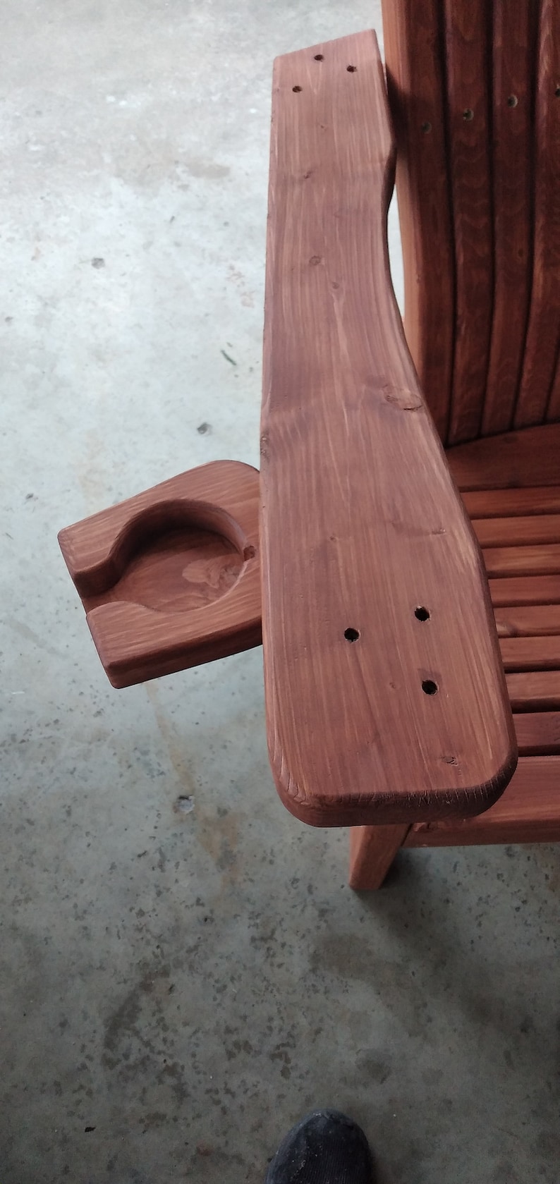 Peut inclure: Une chaise en bois avec un porte-gobelet sur l'accoudoir. La chaise est teint&eacute;e d'une couleur brun rouge&acirc;tre.