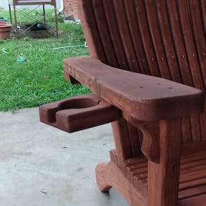 Peut inclure: Une chaise Adirondack en bois avec un porte-gobelet int&eacute;gr&eacute;. La chaise est teint&eacute;e d'une riche couleur brun rouge&acirc;tre.